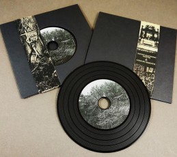 Black vinyl CDs in solid black record-style wallets with brown Manila obi-strips