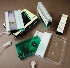 Dark green transparent unprinted cassettes in cases with tracing paper J-cards and Obi strips