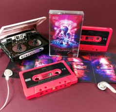 Neon pink cassettes with stickers and J-cards with three additional fold-out panels