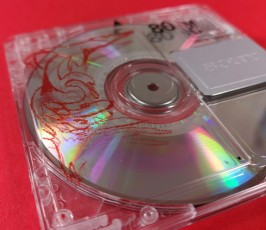 Front of a clear MiniDisc with red and black on-body printing