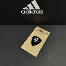 Black guitar picks with white printing on brown Manila cards