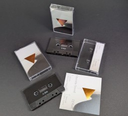 Black cassette tapes in cases with J-cards that have a copper hot foil print