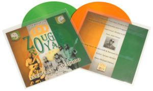 Green and orange vinyl CDs in clear plastic wallets with 2 page inserts