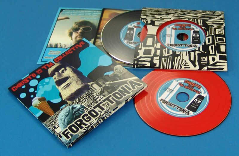 A double vinyl CD four page wallet with a black vinyl DVD and red vinyl CD, plus a booklet