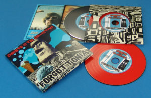 A double vinyl CD four page wallet with a black vinyl DVD and red vinyl CD, plus a booklet