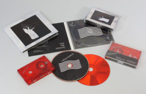 A matching set of transparent red cassettes and red base CDs  in 4 page digipaks