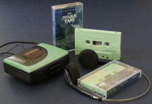 A set of sage green cassettes with white on-body printing