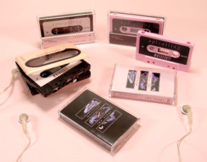 A set of black and baby pink cassettes with J-cards and an additional fold-out panel