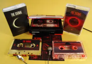 Metallic gold and red glitter cassettes with sticker printing and in cases, with the metallic gold also having outer O-cards