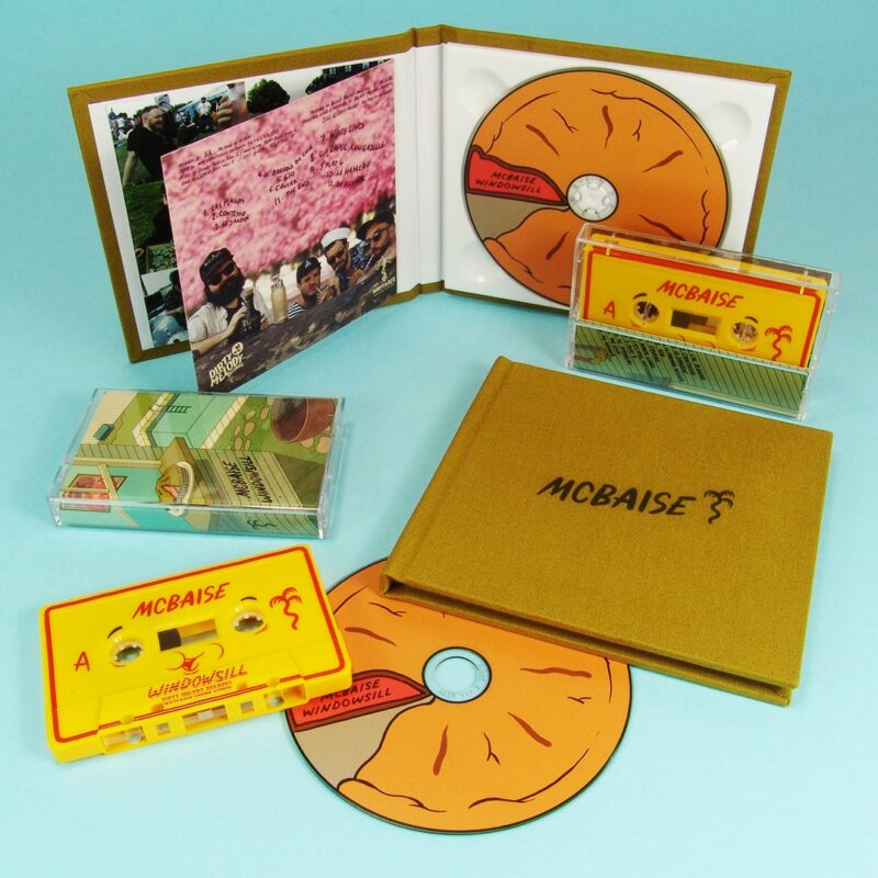 Yellow cassette with full coverage UV LED printing and CDs in hardback linen covered digipaks also with a UV LED cover print