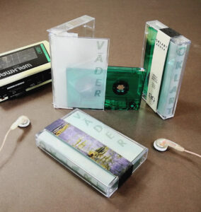 Dark green transparent unprinted cassettes in cases with tracing paper J-cards and Obi strips