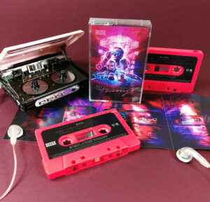 Neon pink cassettes with stickers and J-cards with three additional fold-out panels