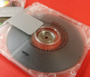 Rear of a clear MiniDisc with red and black on-body printing