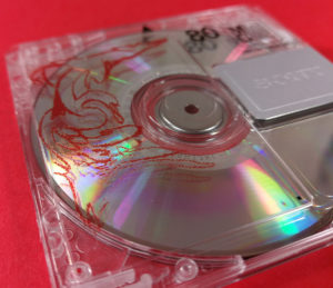 Front of a clear MiniDisc with red and black on-body printing