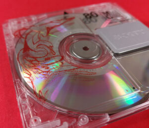 Front of a clear MiniDisc with red and black on-body printing