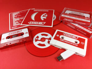 Red vinyl CDs in record-style wallets, red cassette tapes and white USB cassettes