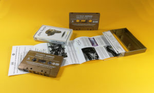 Vintage bronze cassette tapes with white on-body printing in gold cassette cases with clear front windows