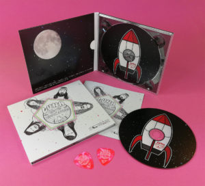 Pink guitar picks and CD digipaks with a booklet for Luna and the Moonhounds