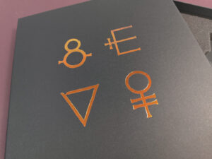 Close-up of copper metallic foil printing on a black A4 quad cassette tape presentation box