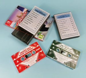 Monopoly-style outer cassette case O-cards for the English and Japanese versions of these tapes