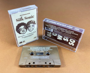 Gold cassette shells with white on-body print in clear cases with 6 panel J-cards