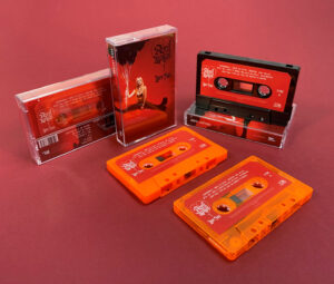 Black, red, orange and transparent orange cassette shells with sticker printing in clear cases with full colour J-cards