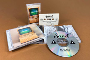 A matching set of cream cassettes with brown on-body print and CDs in jewel cases