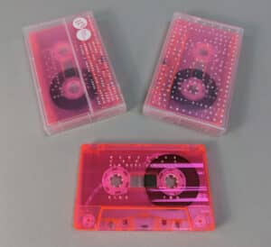 Transparent pink cassette tapes with white on-body printing, packed in clear frosted cases also with white on-body printing